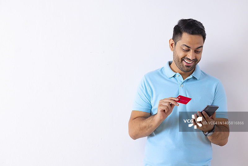 一名年轻人使用信用卡通过智能手机在线购物的画像图片素材