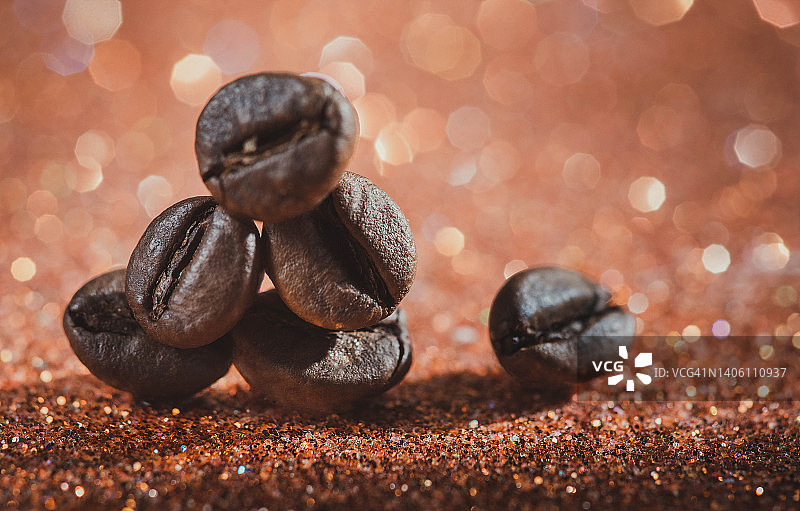 咖啡豆在闪亮的黑色背景下的特写。咖啡的背景。用咖啡豆复制空间。咖啡豆放在餐桌上。咖啡豆的特写图片素材