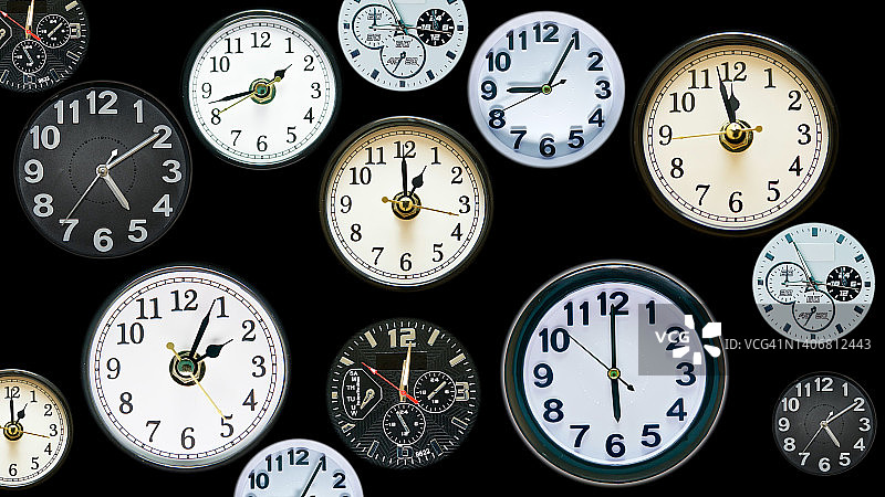 各种时钟在一帧。时间概念镜头由真实的，不同的时钟面制成。黑色背景显示不同的时间。图片素材