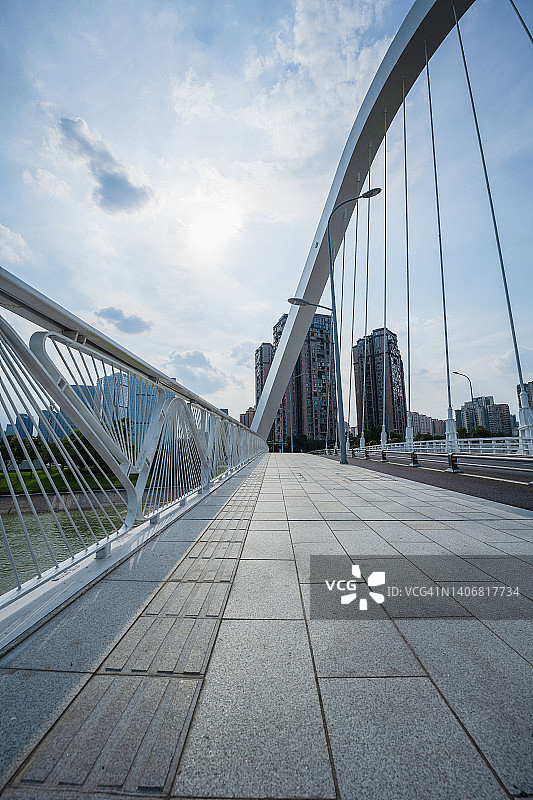 阳光明媚的河滨大桥和现代城市建筑图片素材