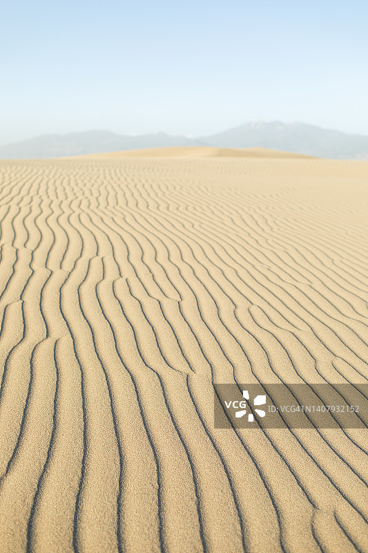极简主义的沙漠景观。白色的沙丘与山景。周围没有人图片素材
