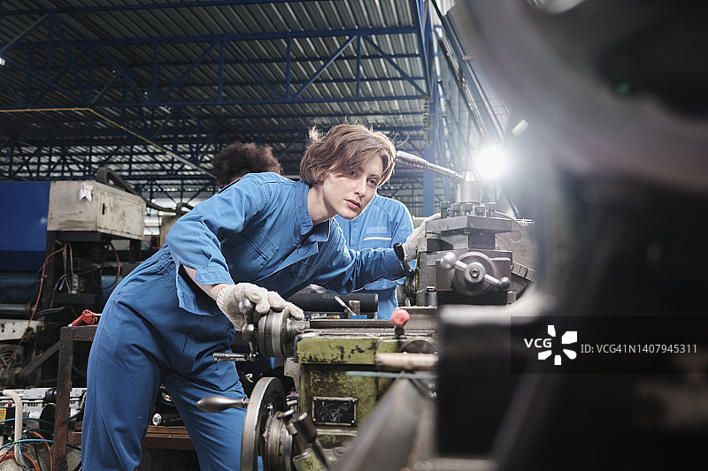 专业的年轻白人女工在金属制品制造厂工作。图片素材