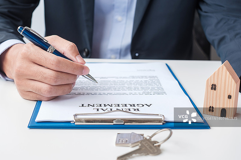男子签署家庭合同文件。合同协议、房地产、买卖和保险概念图片素材