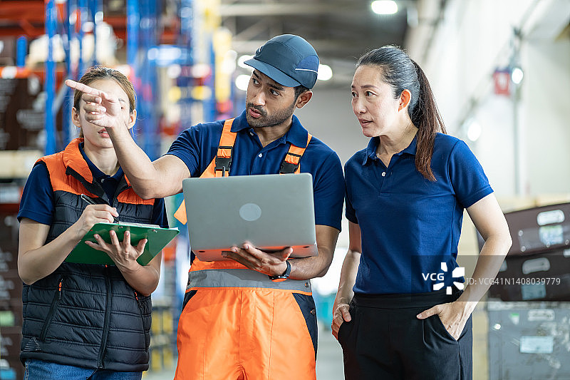 钢盔组的亚洲女工程师和叉车工人在平板电脑上订购详细信息，以检查货架上的货物和物资，仓库有货物背景图片素材