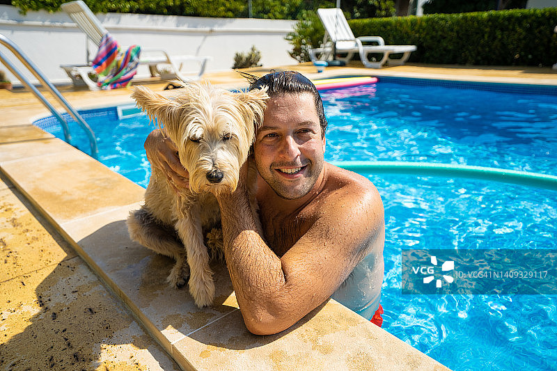 一个人和狗在泳池里玩图片素材