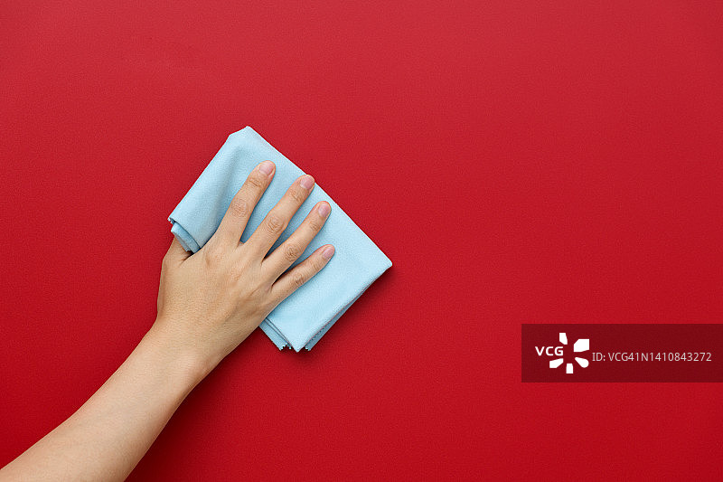 女人用抹布手工清洁红墙图片素材