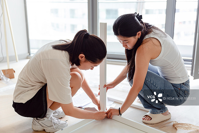 两个亚洲女人在组装家具图片素材