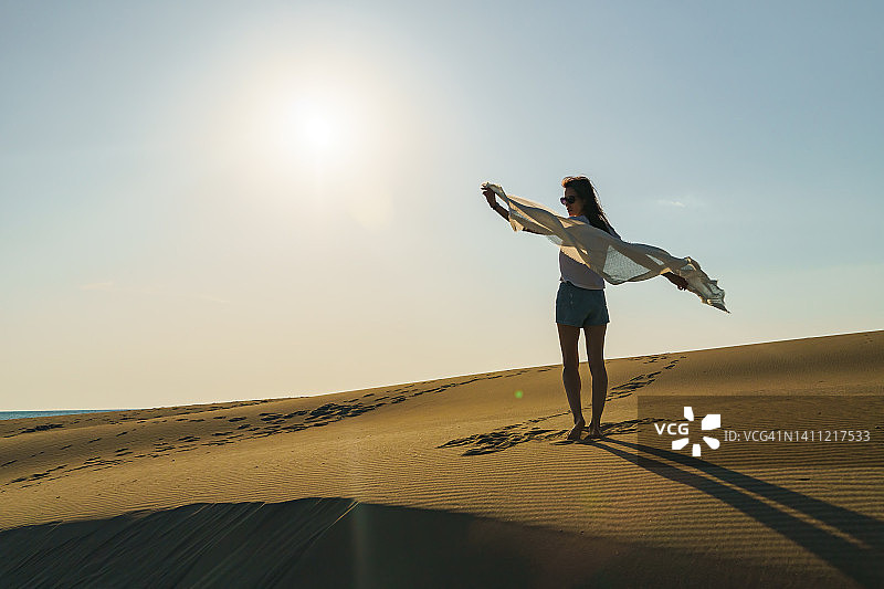 站在沙漠景观起伏沙丘上的女人图片素材