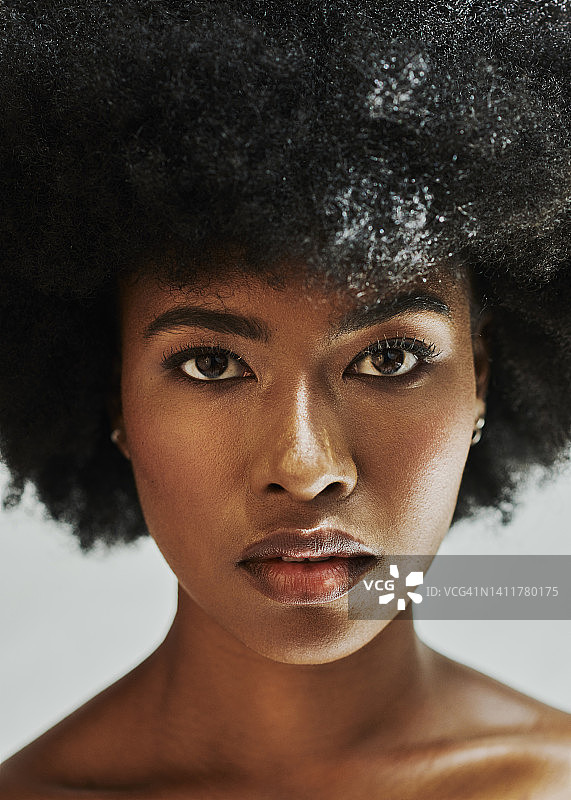 一个黑人妇女的脸被孤立在白色背景下的肖像。一个自信的非洲裔美国女性的特写与时尚的爆炸头和完美的皮肤，性感，赤膊和光芒四射的女性力量图片素材