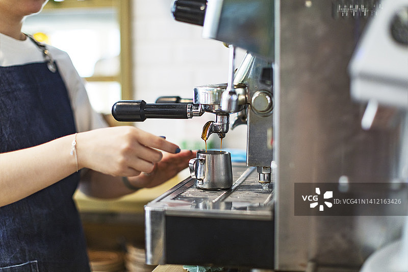 咖啡师在咖啡馆用咖啡机煮咖啡图片素材