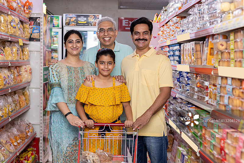 快乐的印度几代人家庭在超市购物图片素材