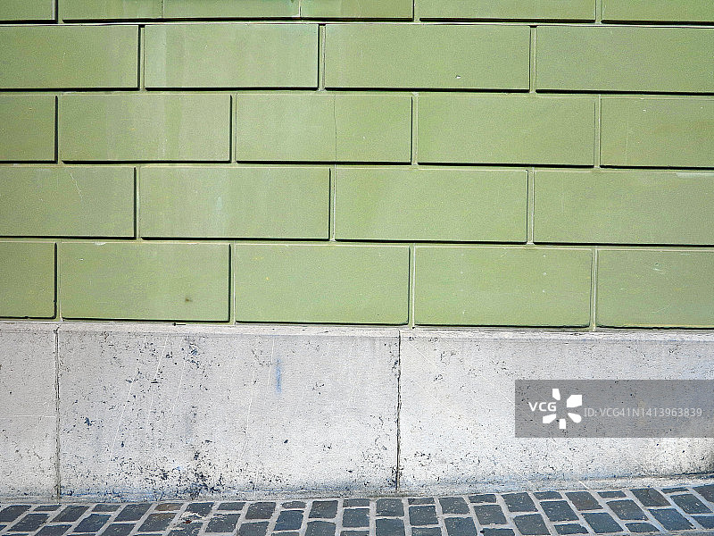 墙壁漆成绿色，石头是灰色的，街道上铺着鹅卵石图片素材