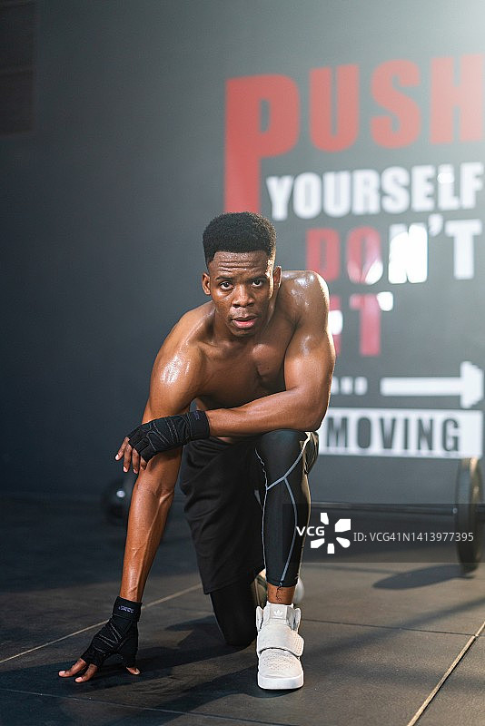 英俊和肌肉发达的非洲黑人男性在健身房做热身运动图片素材