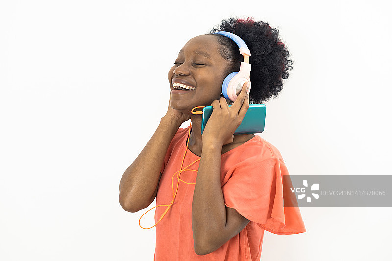 一个年轻的非洲妇女的肖像与音乐的乐趣图片素材