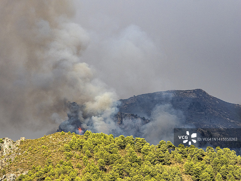地中海森林山景与森林大火的烟和火。图片素材