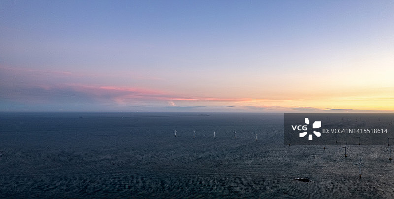 日出时海上风力发电厂的鸟瞰图图片素材