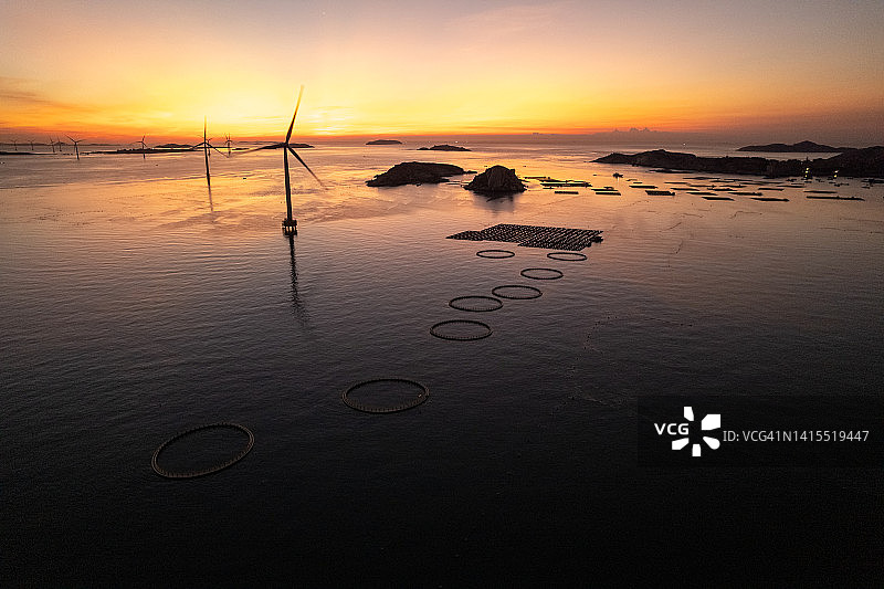 海上风力涡轮机和渔场在日出图片素材