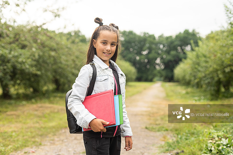 开学第一天。快乐的小女孩小学生跑去上课。概念回到学校。图片素材