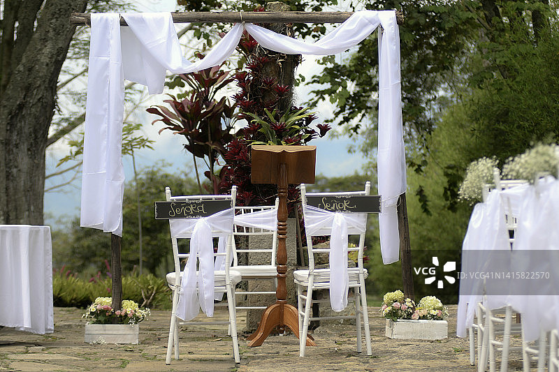 夏季户外婚礼装饰。用花装饰的白色椅子图片素材