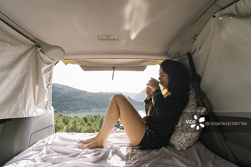 度假时在货车里喝咖啡的女人图片素材