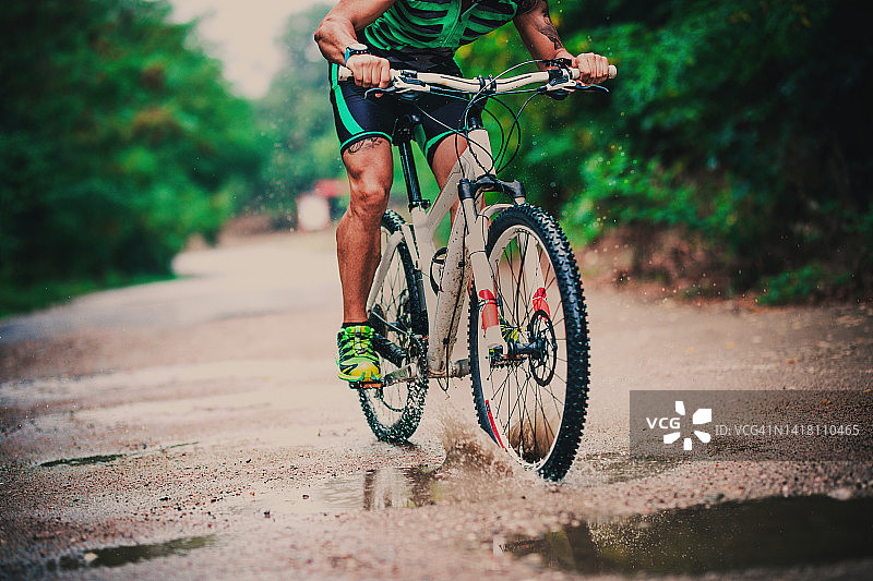 男性山地自行车手在森林里骑行图片素材