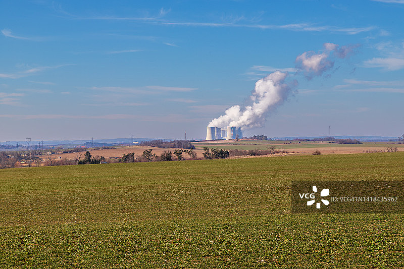 欧洲捷克共和国的杜科瓦尼核电站。烟冷却塔。天空中有云。背景是高地的自然风光。图片素材