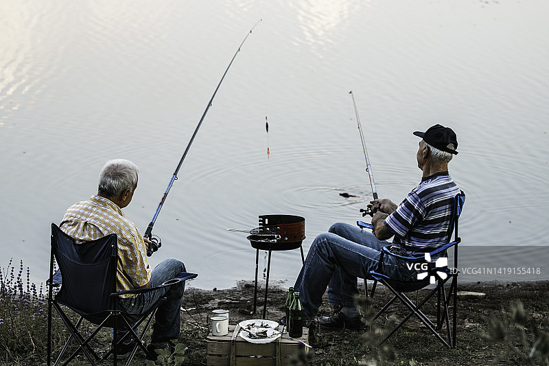 两个渔夫在湖上。高级钓鱼的人。放松的时间图片素材