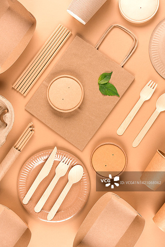 纸制餐具和木制餐具的浅棕色背景。街头食品可持续纸质包装，零浪费包装理念。垂直平层组合图片素材