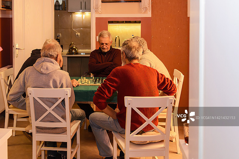 在一次社交会上，一群活跃的老人正在下棋。图片素材