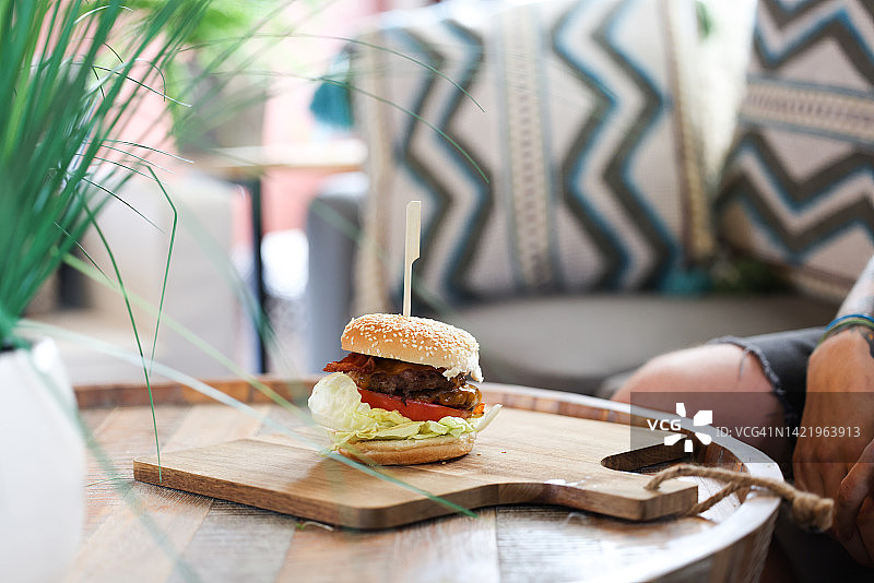 美食汉堡放在木制砧板上，配上新鲜的食材图片素材