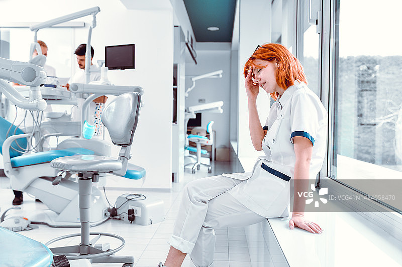 压力大的女牙医在团队工作中休息图片素材