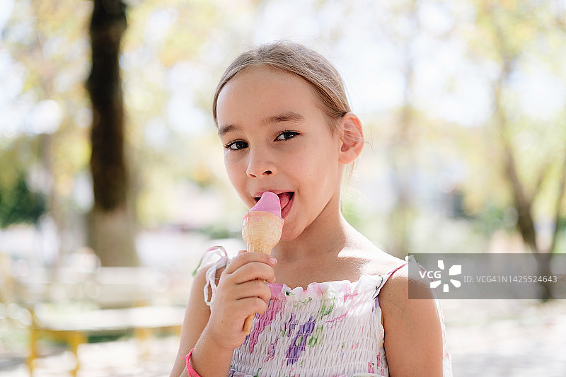 夏天小女孩在户外吃冰淇淋的画像图片素材