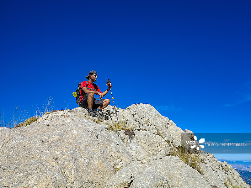 背着背包的男子在山顶休息时欣赏风景图片素材