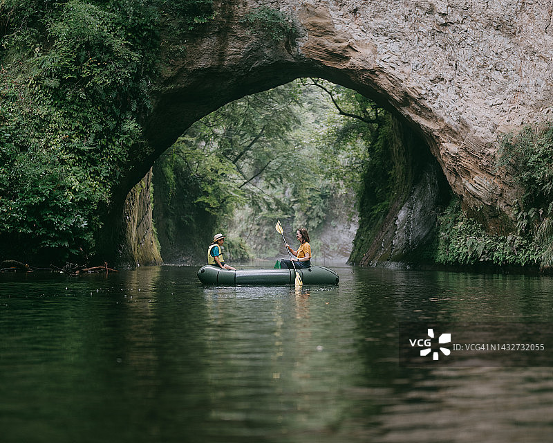 日本千叶，母亲和孩子在有洞穴的河上划皮艇图片素材
