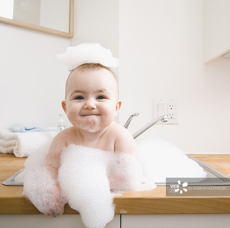 宝宝在水池里洗澡，微笑着图片素材