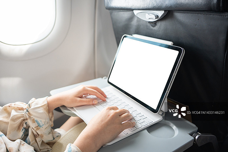 在飞机上用笔记本电脑工作的妇女图片素材