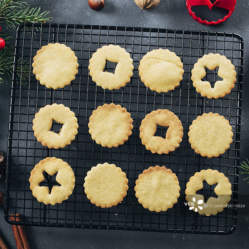 圣诞Linzer饼干在深蓝色的桌子背景。假日甜食。制作饼干的过程。俯视图，平铺图片素材