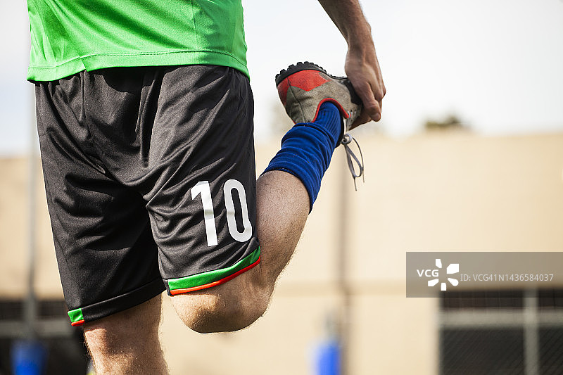 男足球运动员伸展腿的中段图片素材