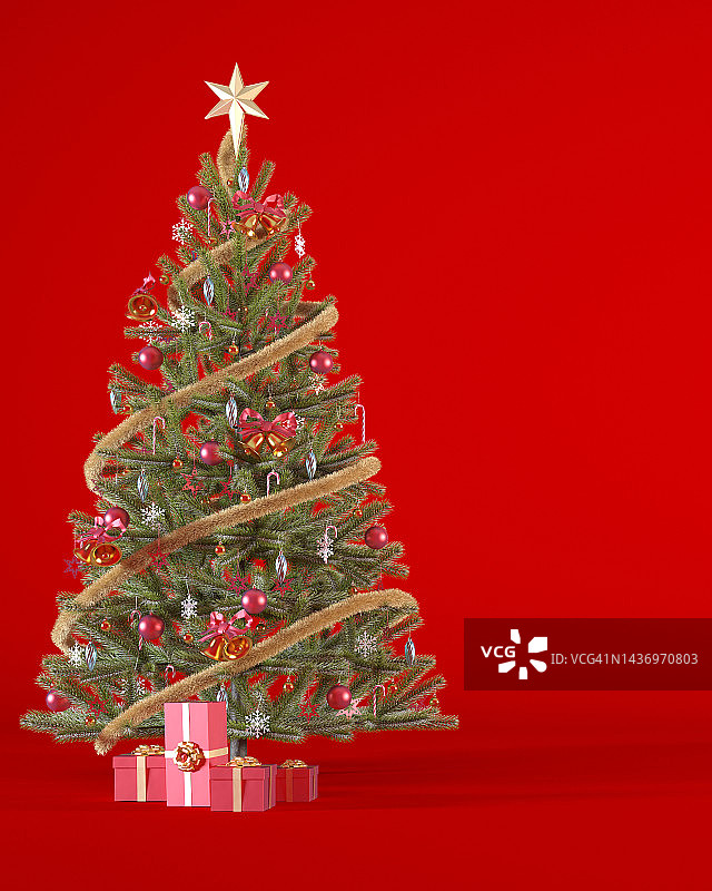 圣诞树上装饰着红色和金色的饰品和红色礼品盒上的红色垂直背景与复制空间。图片素材