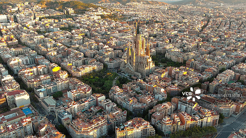 日出时的巴塞罗那城市天际线和圣家大教堂。西班牙加泰罗尼亚。城市景观与典型的城市八边形街区图片素材