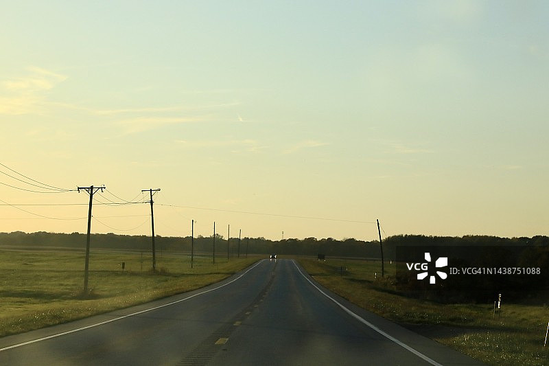 在乡村道路上开车时，阳光照射在挡风玻璃上图片素材
