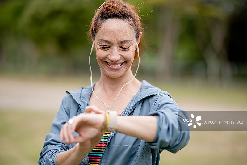 一位女士在锻炼时看到她的智能手表图片素材