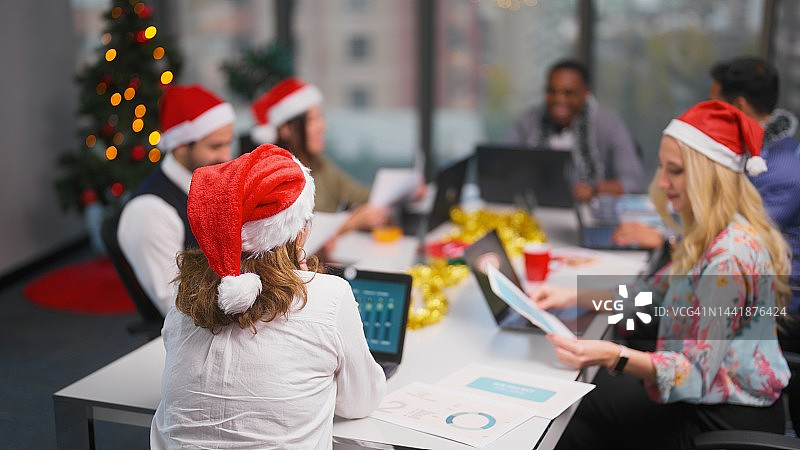 一群多种族的商务人士在圣诞节期间一起工作，在办公室举行商务会议图片素材