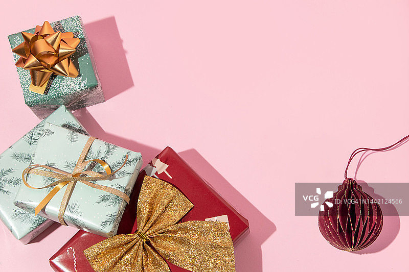 圣诞创意复制空间与礼物和圣诞装饰在柔和的粉色背景。八九十年代的审美时尚假日概念。迷你新年派对的想法。图片素材
