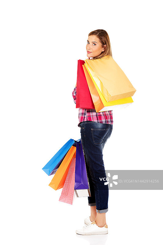 一名年轻的波兰女子摆着她的购物袋在白色背景上图片素材