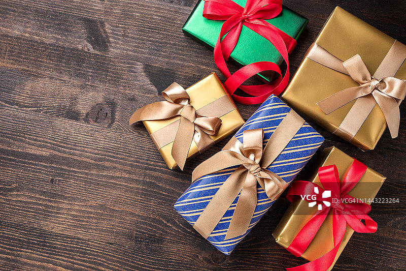 节日圣诞新年背景彩色礼盒和节日装饰的木材背景。新年礼物和圣诞礼物俯视图图片素材