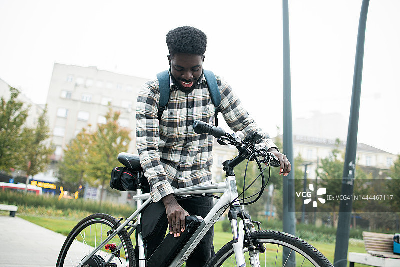 年轻人骑着电动自行车穿过城市图片素材