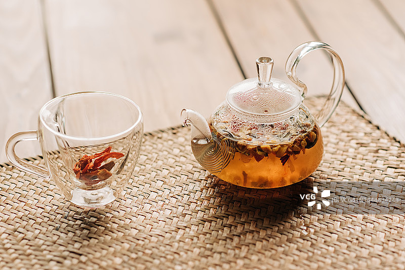 玻璃茶壶沙棘茶，选择性聚焦，乡土背景，方形形象图片素材