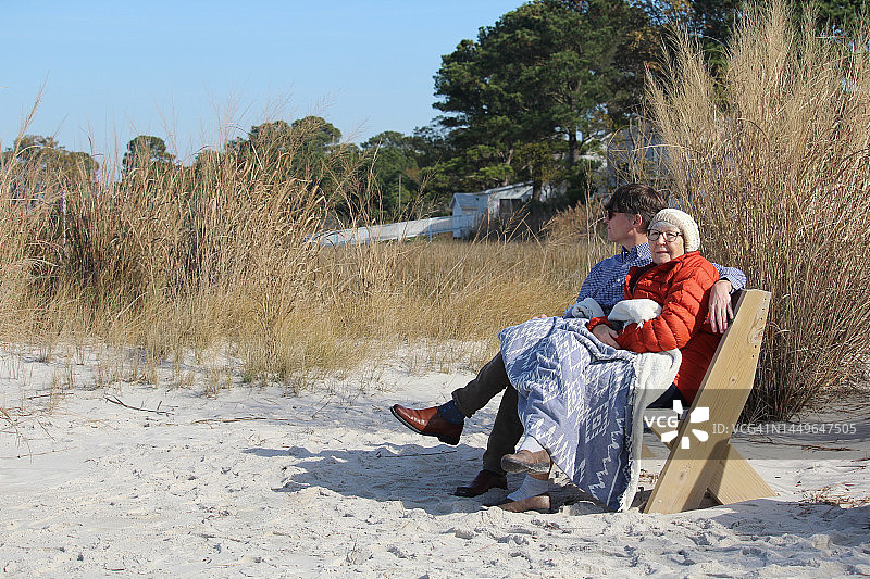 感恩节那天，成年儿子和母亲坐在海滩上。东部海岸。丹吉尔的声音。切萨皮克湾。图片素材