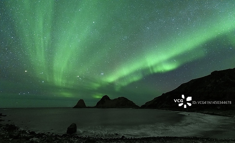 北极光或极光在繁星密布的夜空中在挪威北部的Nykvag海滩图片素材